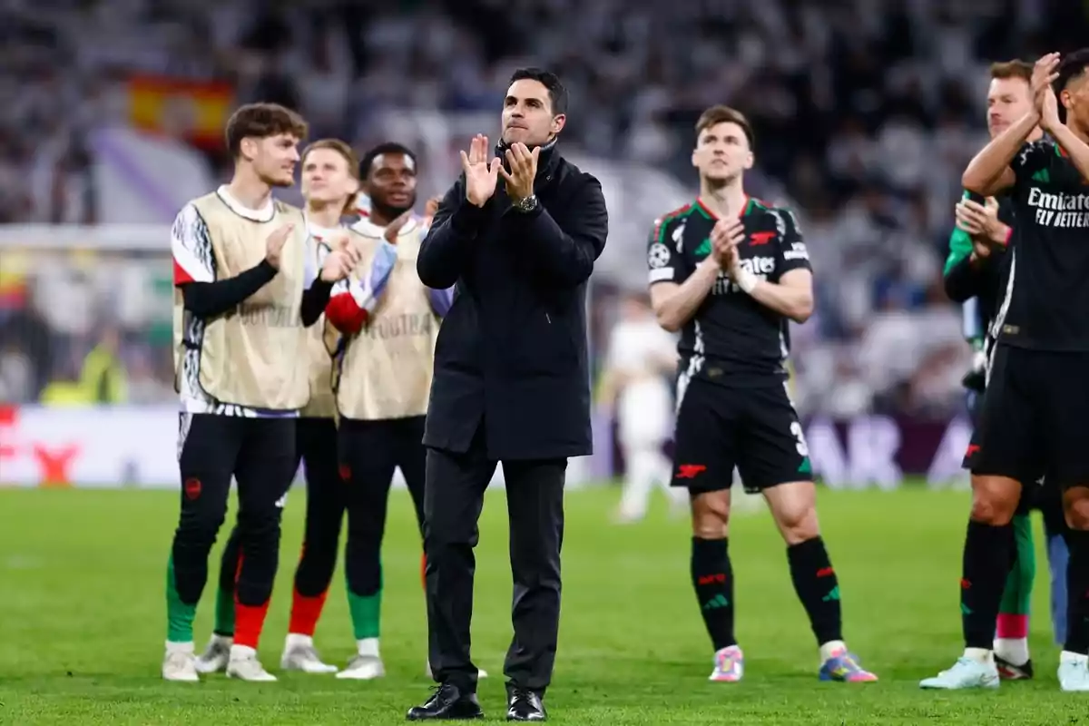 Entrenador i jugadors d’un equip de futbol aplaudint al camp després d’un partit Entrenador i jugadors d’un equip de futbol aplaudint al camp després d’un partit