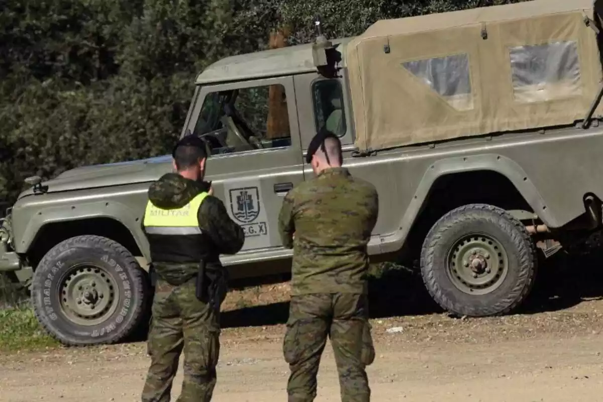 Dos militars de l'Exèrcit d'Espanya d'esquena davant d'un tot terreny verd de l'Exèrcit conversant