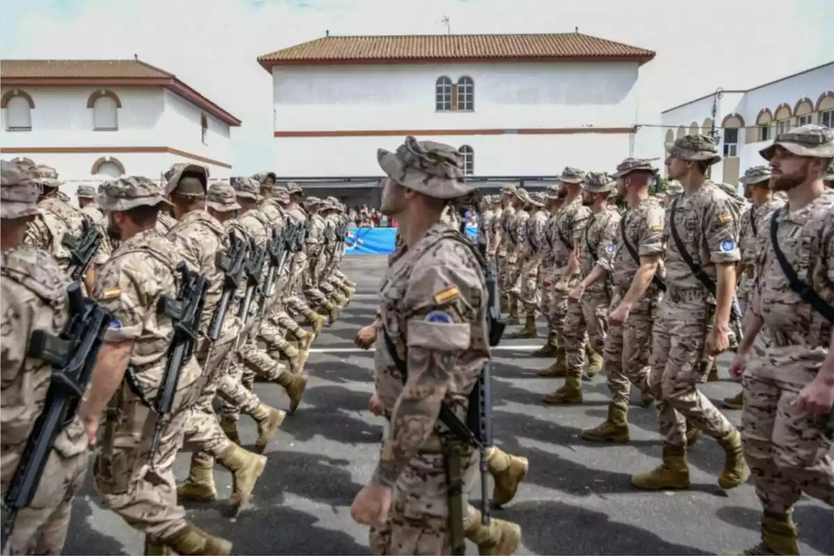 Diversos militars de l'exèrcit desfilant en un carrer amb uniforme oficial