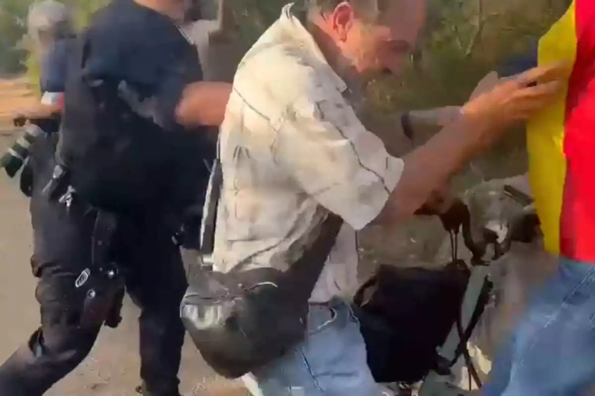 Captura del vídeo del moment en què una força de seguretat empeny un ciutadà amb una samarreta ideològica catalana