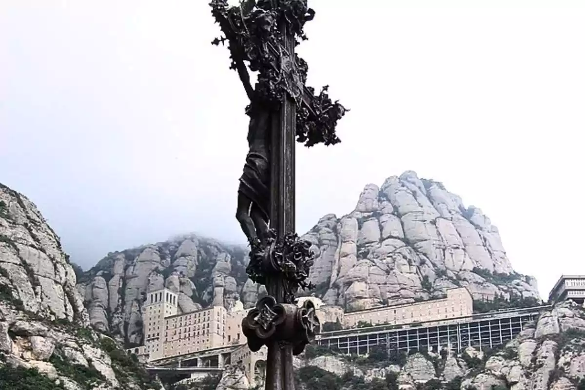 Crucifix de la muntanya de Montserrat amb el monestir de fons