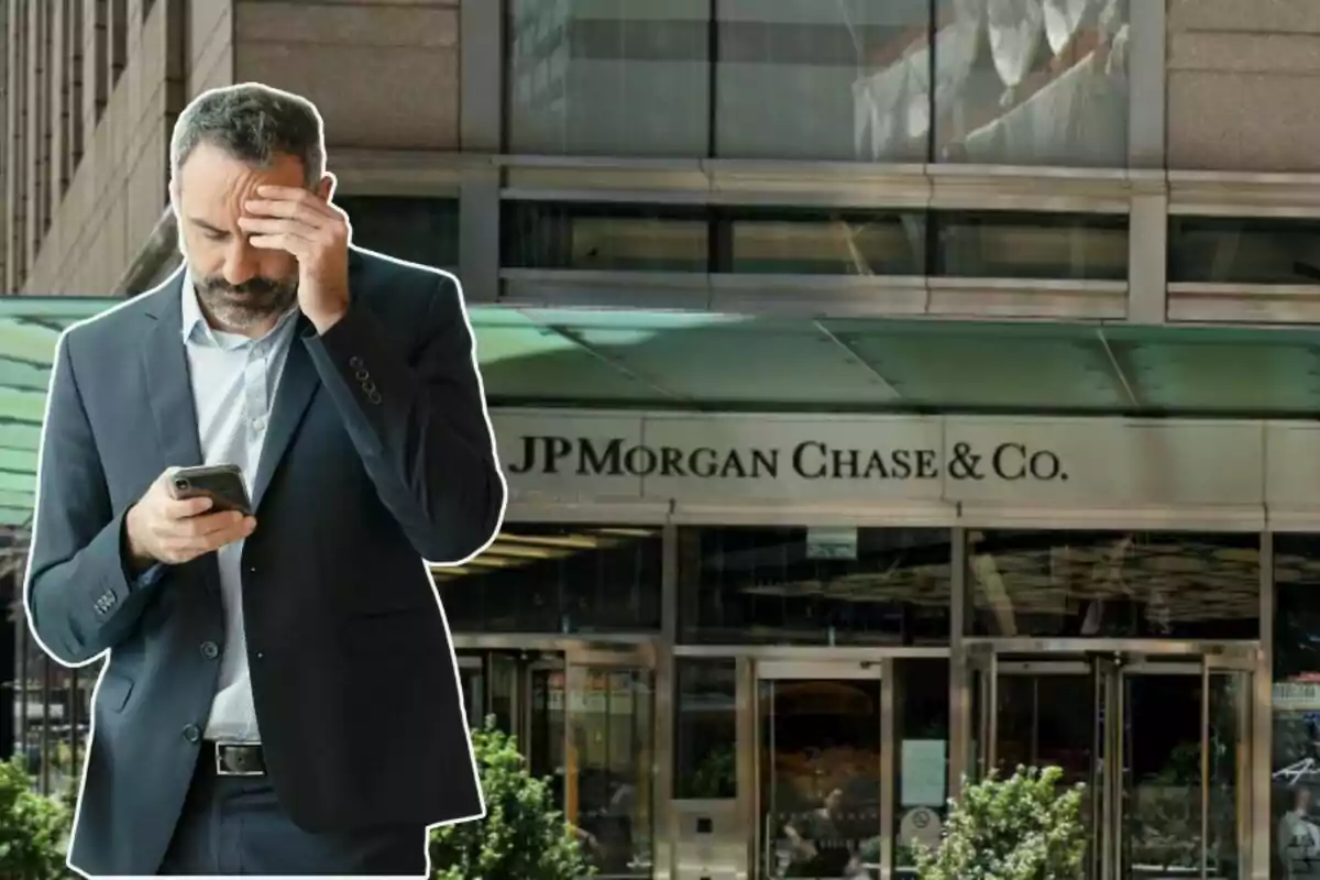 A man in a dark suit looks worried as he checks his phone in front of a JP Morgan Chase & Co. building.