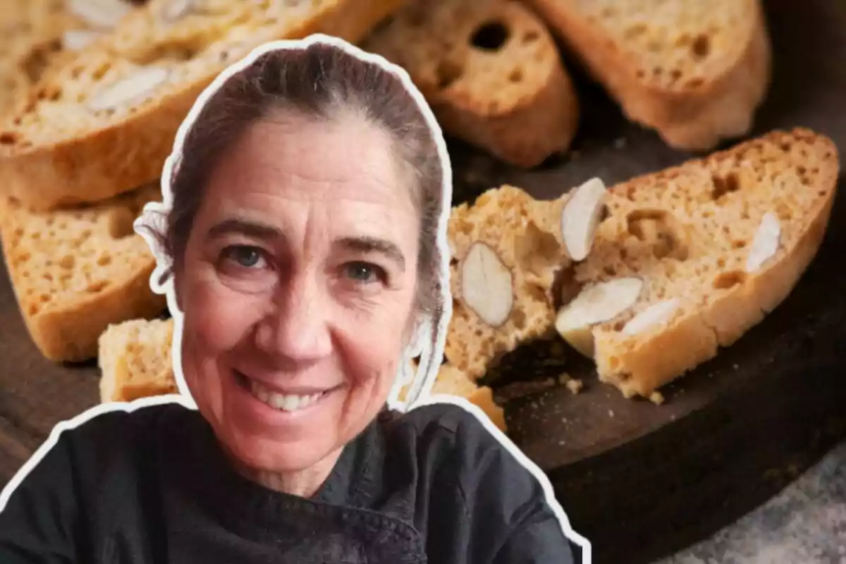 Una mujer sonriente con cabello recogido frente a un fondo de galletas biscotti con almendras.