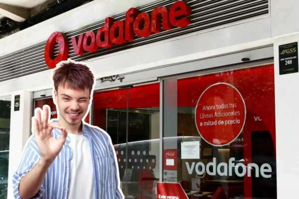 Una botiga de Vodafone, amb un noi al davant fent un gest d'alegria