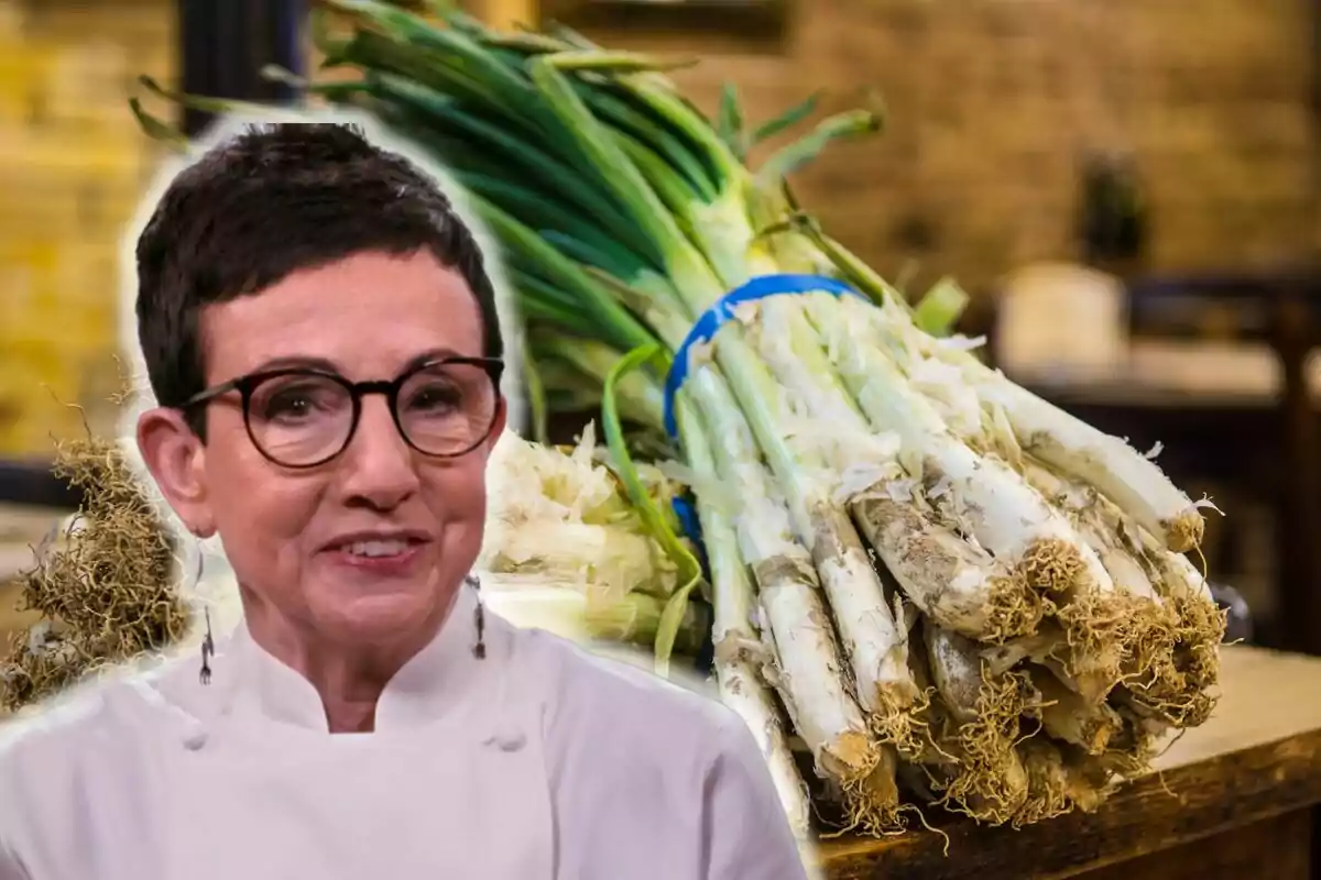 Carme Ruscalleda con gafas y chaqueta de chef está frente a un montón de calçots sobre una mesa de madera.