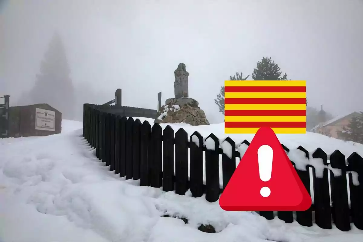 Una estatua en un paisaje nevado con una cerca de madera y un cielo nublado.