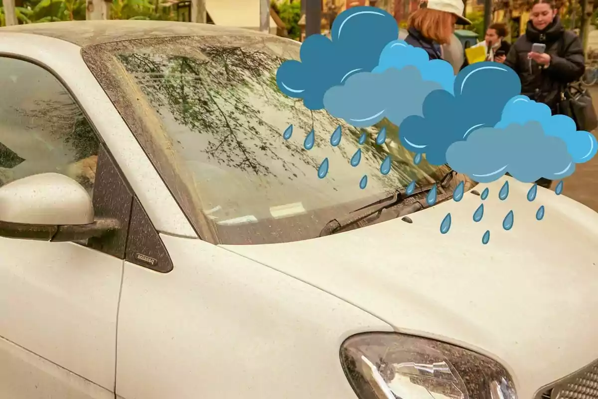 Un coche blanco sucio con un dibujo de nubes y gotas de lluvia sobre el parabrisas.