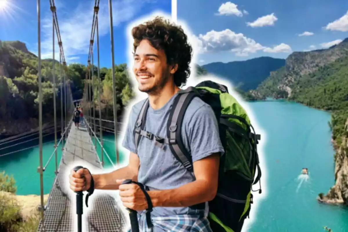 Un home somrient amb una motxilla gran i bastons de senderisme, posant davant d'un paisatge natural amb un pont penjant i un llac d'aigües turqueses envoltat de muntanyes.