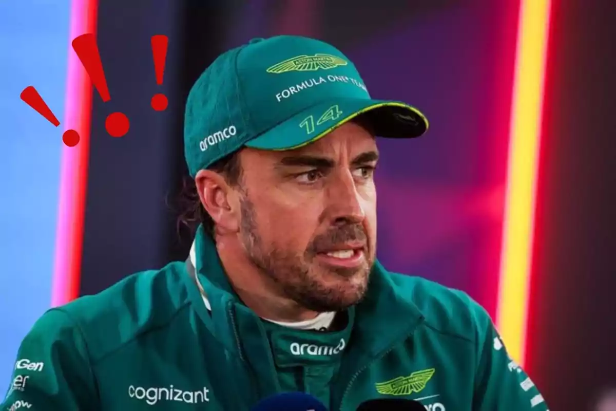 A man with a cap and a green motorsport team jacket, with a serious expression and red exclamation marks above his head.