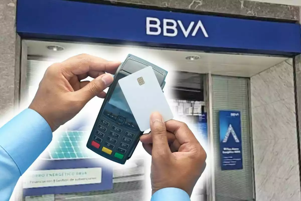 Persona sosteniendo una terminal de pago y una tarjeta frente a una sucursal de BBVA.