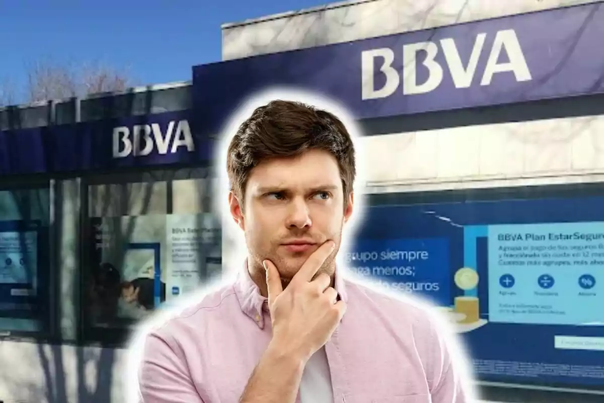 Un home pensatiu davant d?una sucursal del banc BBVA.