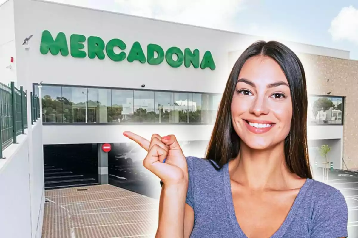 A smiling woman points to a building with the Mercadona sign.