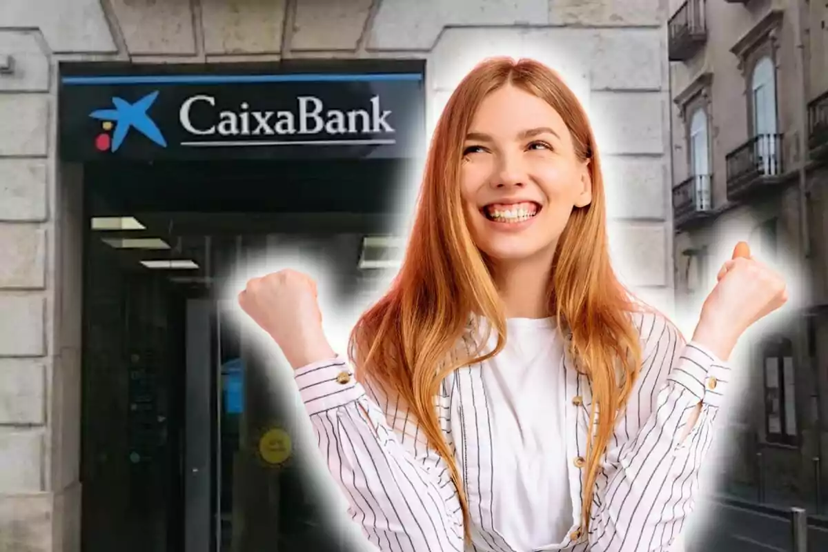 Una dona somrient amb els punys aixecats davant d'una sucursal de CaixaBank.