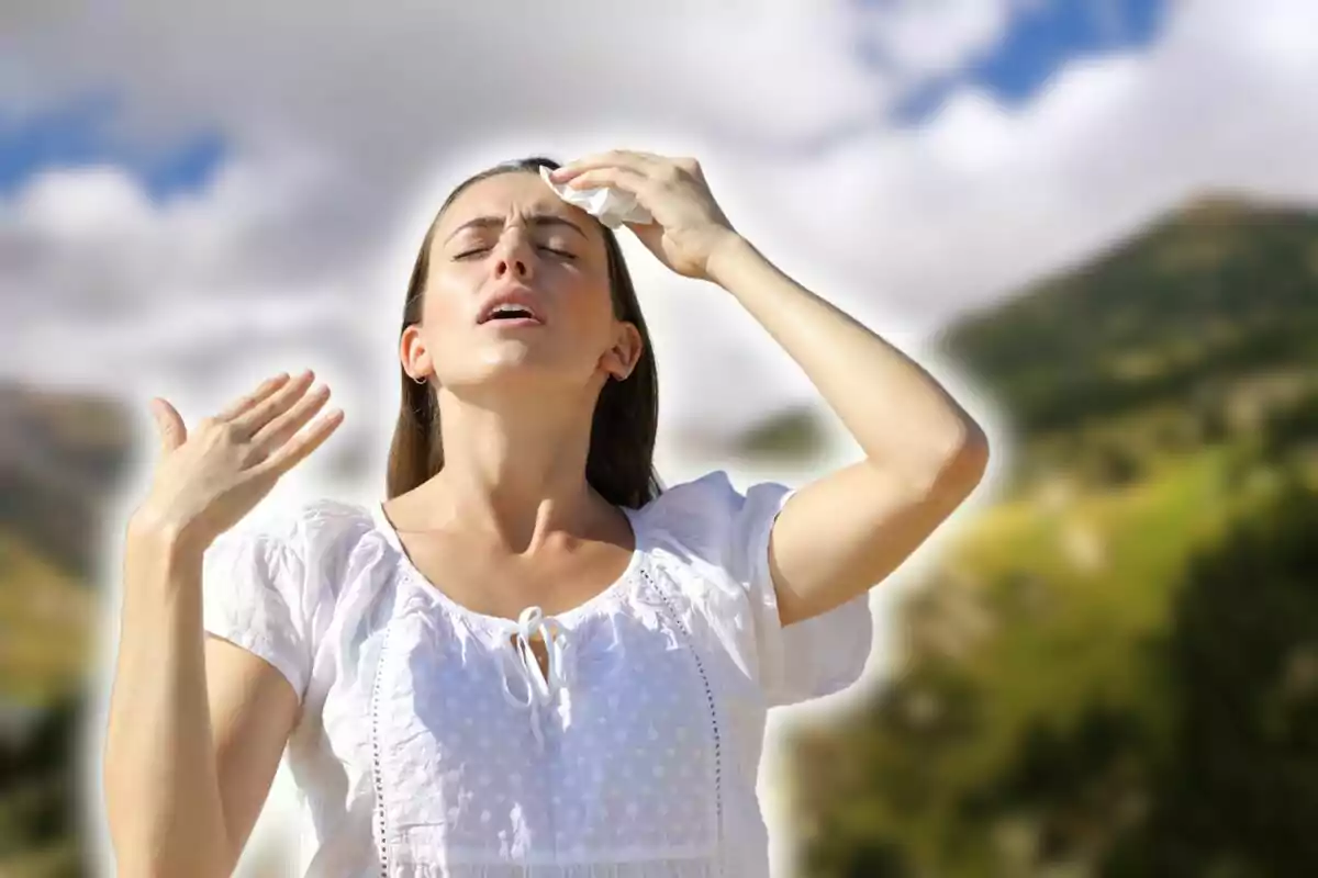 Persona amb camisa blanca assecant-se la suor del front en un dia assolellat a l'aire lliure.