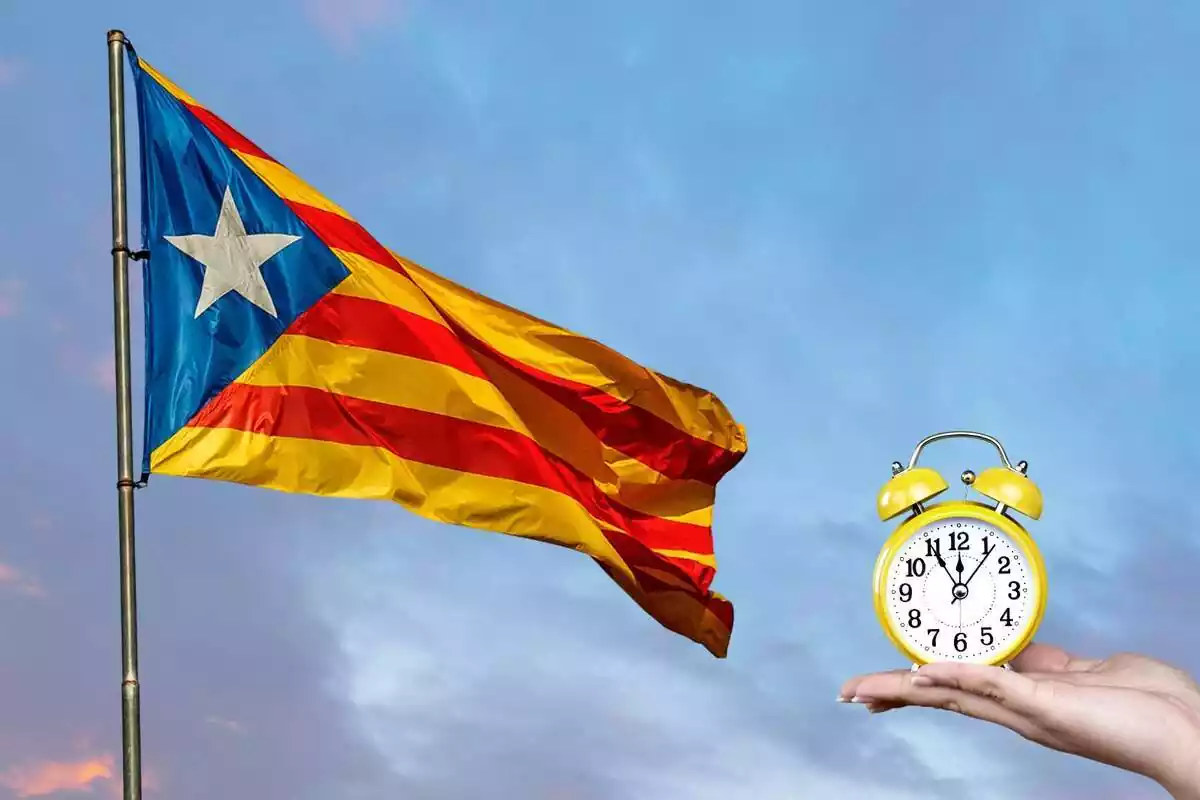 Imatge d´una bandera independentista de Catalunya i, al costat, una mà subjectant un rellotge
