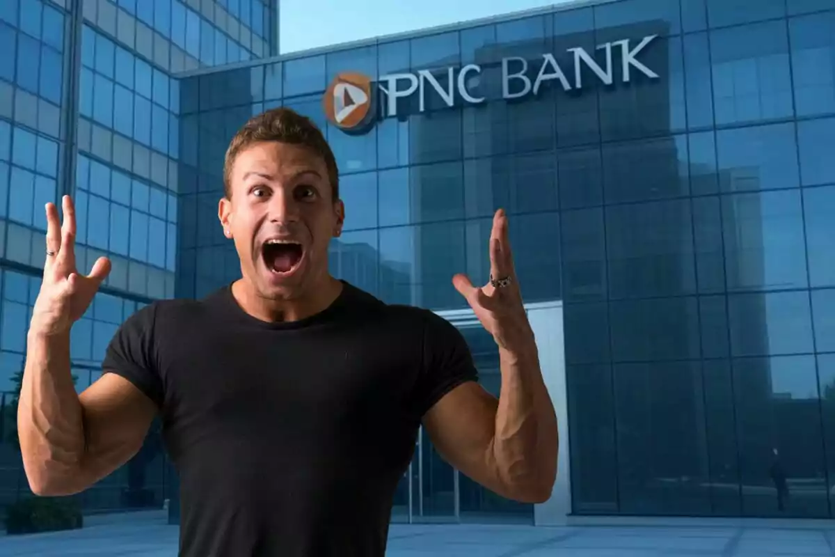 Un hombre con expresión de sorpresa o emoción frente a un edificio de PNC Bank.