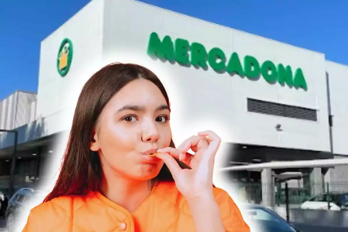 A person in an orange jacket is in front of a Mercadona building, putting some food in their mouth.