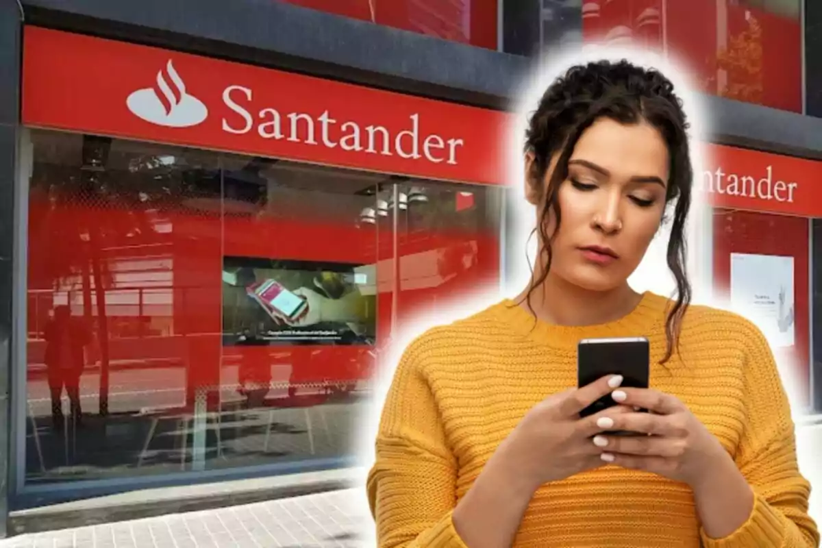 Dona usant un telèfon mòbil davant d'una sucursal del banc Santander.