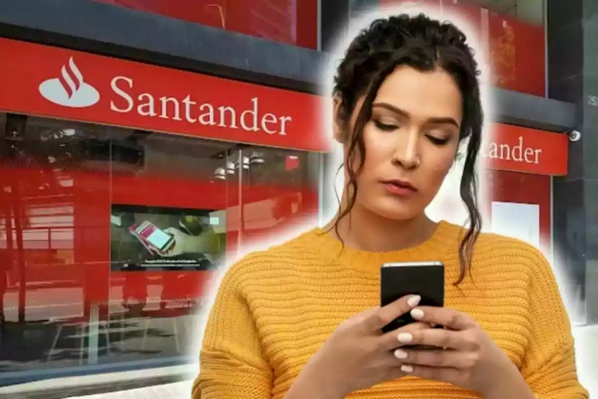 Dona amb suèter groc usant un telèfon davant d'una sucursal bancària del Banco Santander.