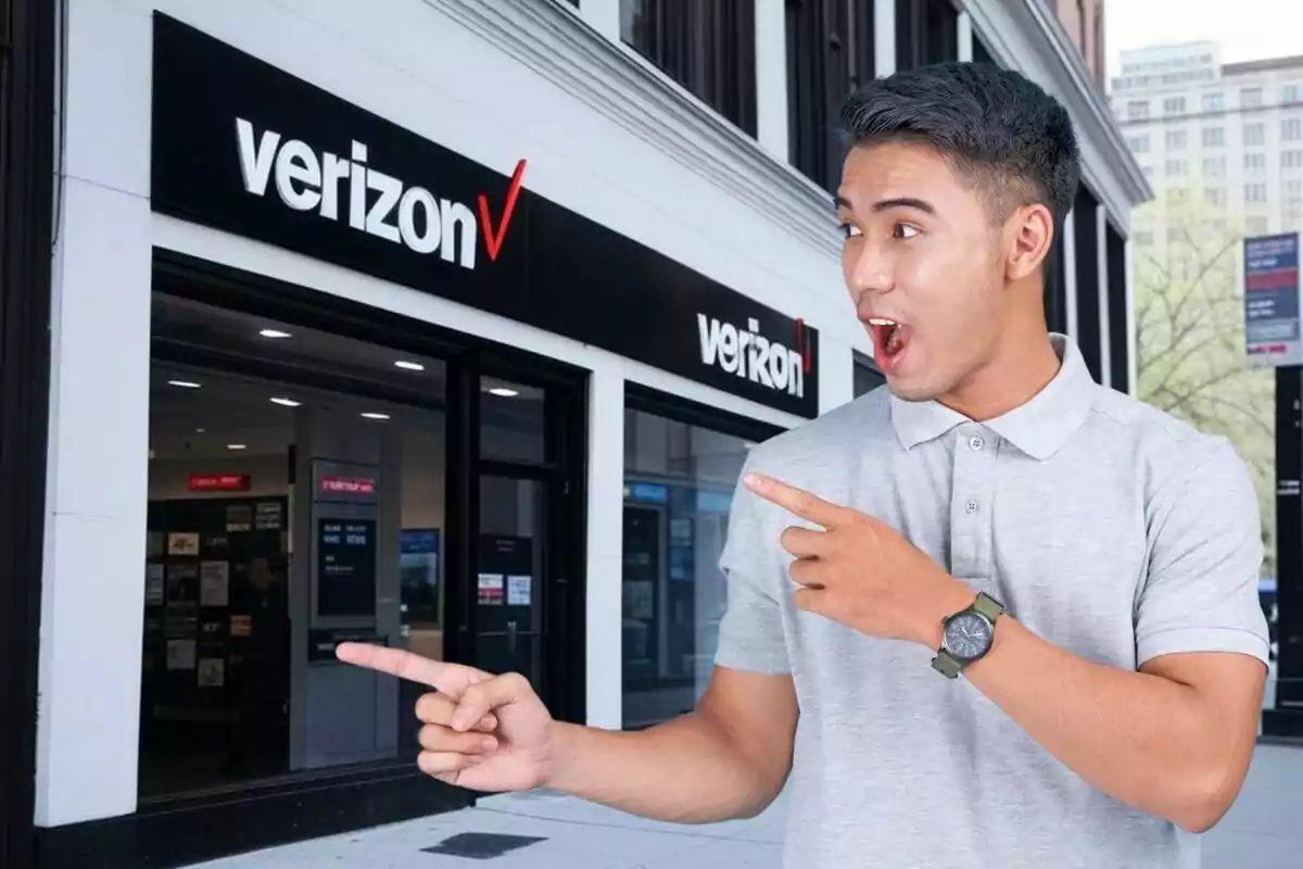 Un hombre sorprendido señala hacia una tienda de Verizon en la calle. Un hombre sorprendido señala hacia una tienda de Verizon en la calle.