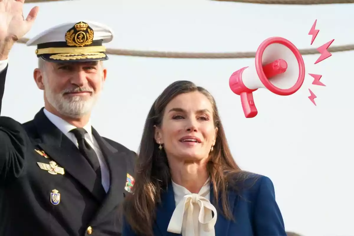 Felip VI amb uniforme naval i Letícia somrient estan junts a l'aire lliure, amb un megàfon il·lustrat al costat d'ells.