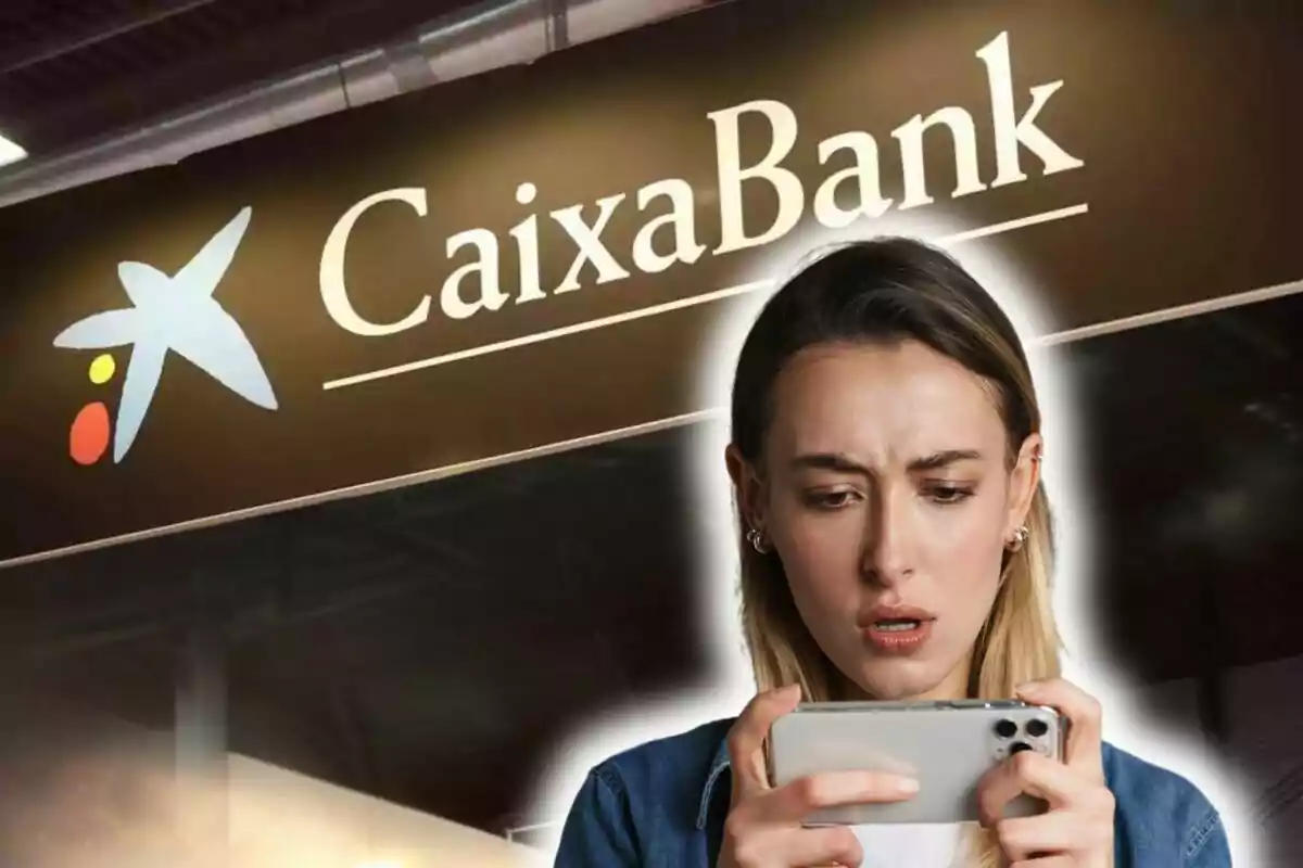 Una persona mirant el telèfon amb expressió de sorpresa davant d'un cartell de CaixaBank.