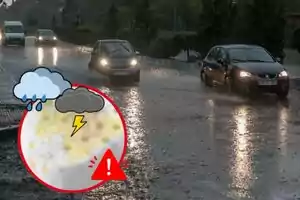 Cotxes circulant per una carretera inundada sota la pluja amb un gràfic d'advertiment meteorològic en primer pla.