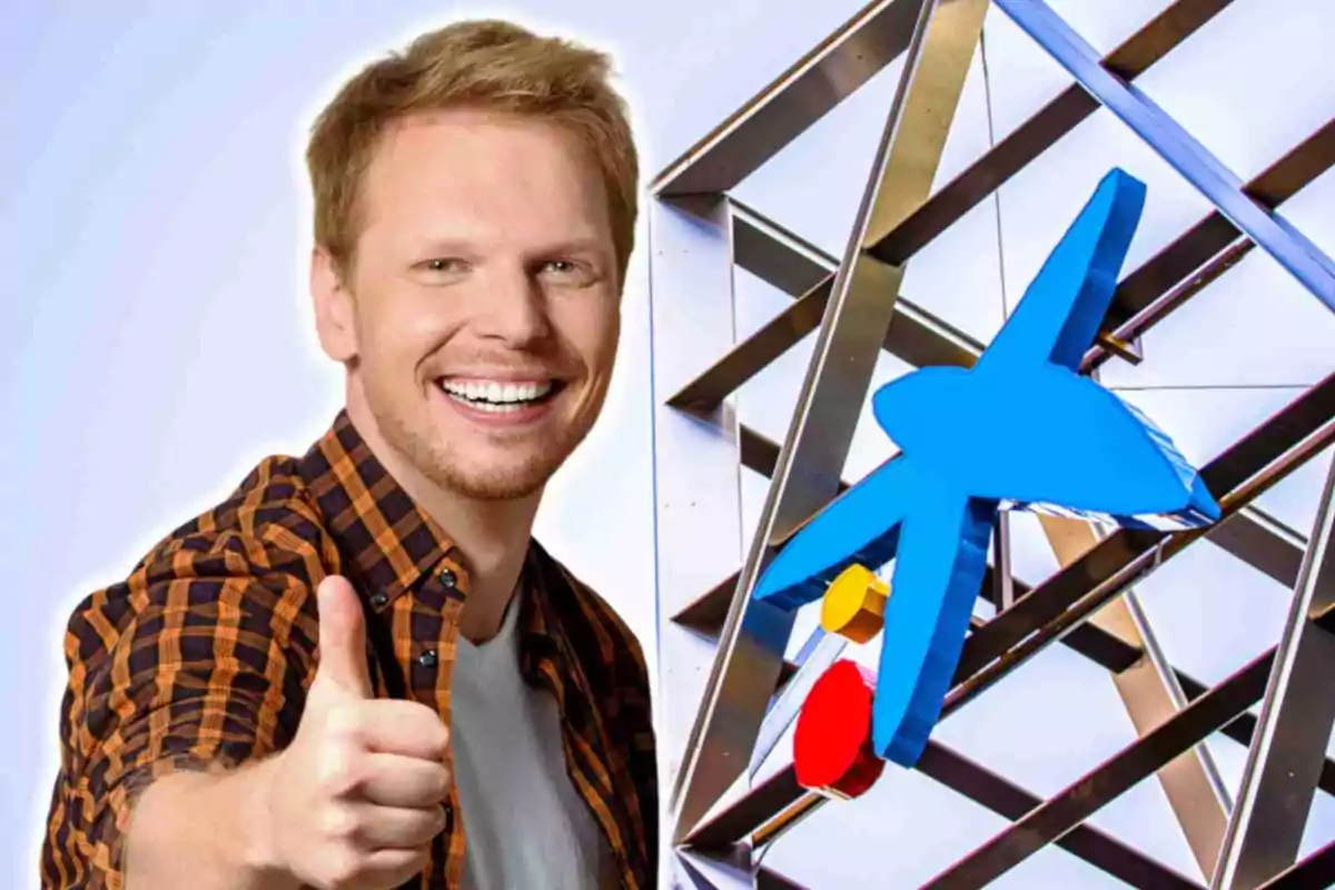Hombre sonriente con camisa de cuadros haciendo señal de pulgar arriba junto a una escultura metálica con una figura azul de CaixaBank