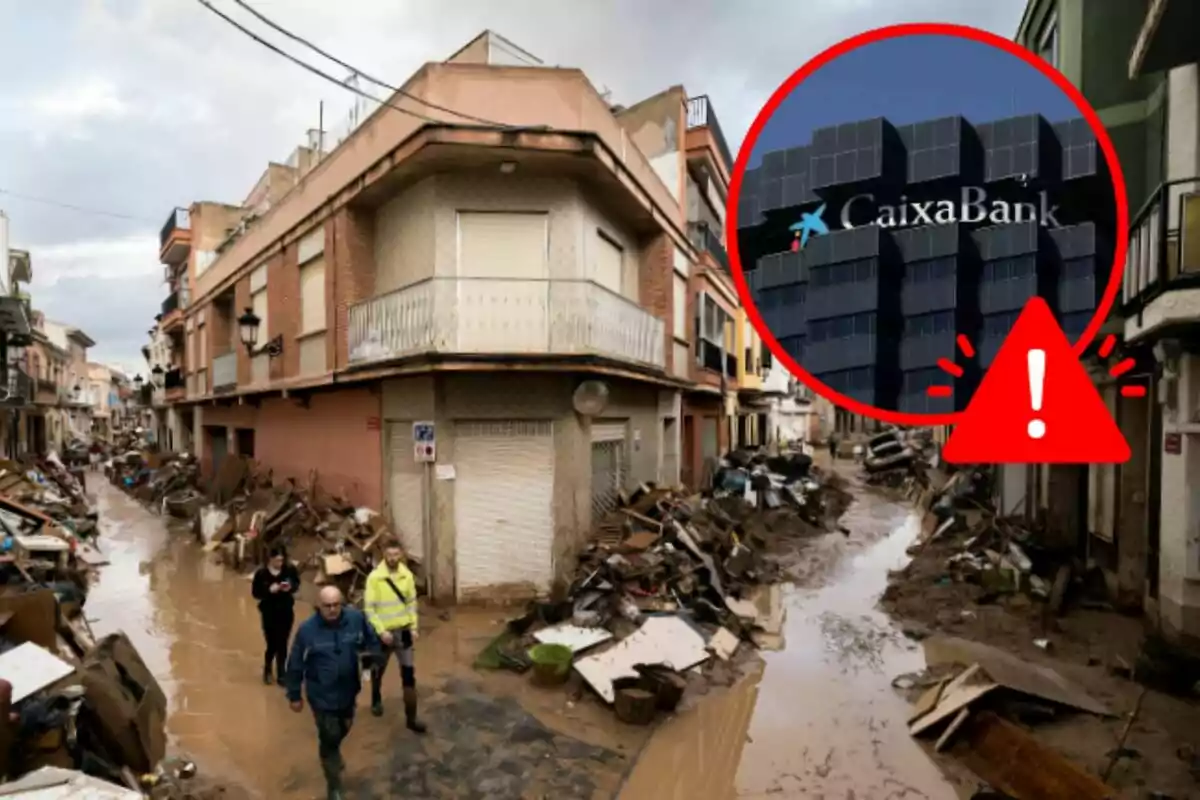 Persones caminant per un carrer inundat i ple de runes amb un edifici de CaixaBank ressaltat en un cercle vermell amb un signe d'advertència.