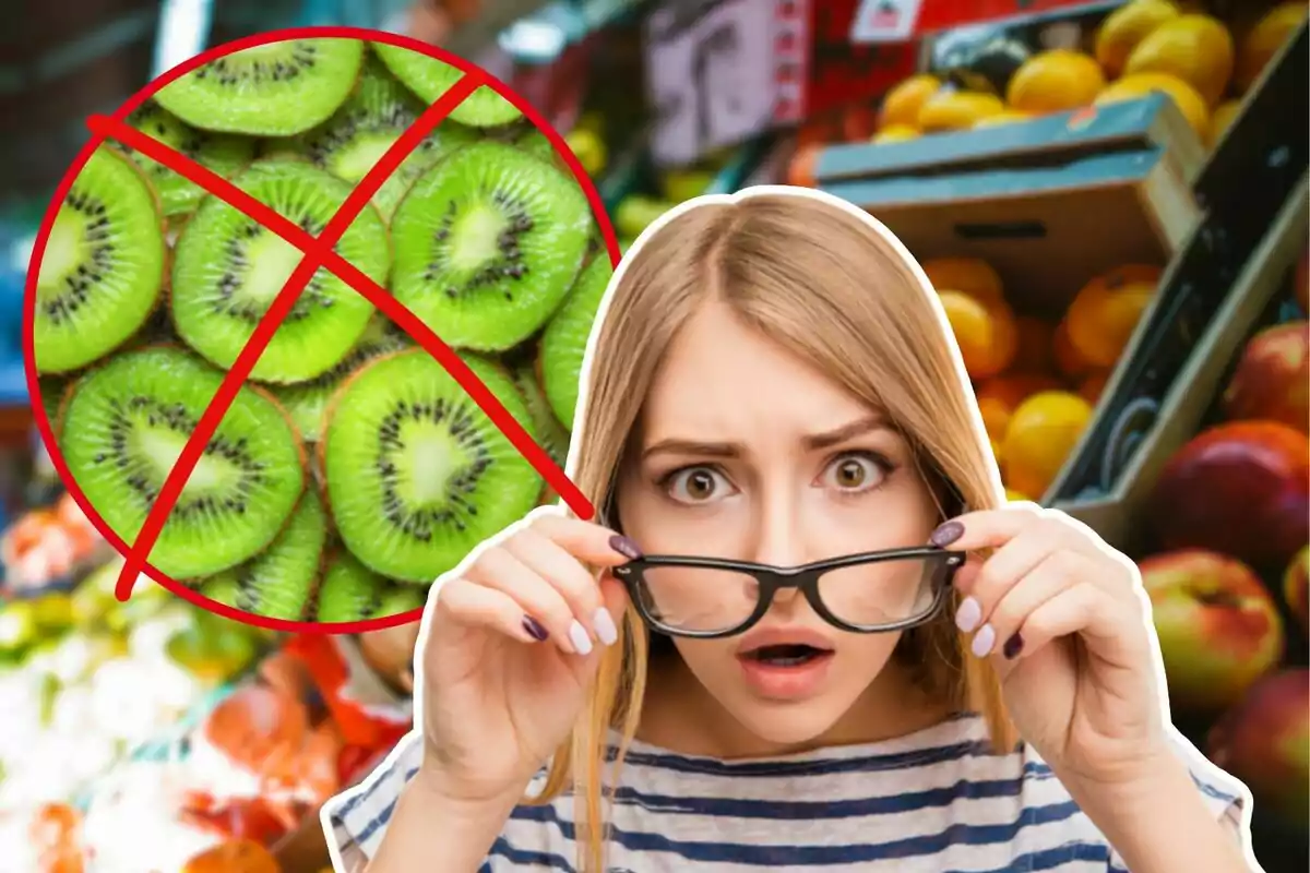 Una mujer con expresión de sorpresa sostiene sus gafas mientras observa un círculo rojo con una línea cruzada sobre una imagen de kiwis en un mercado de frutas.