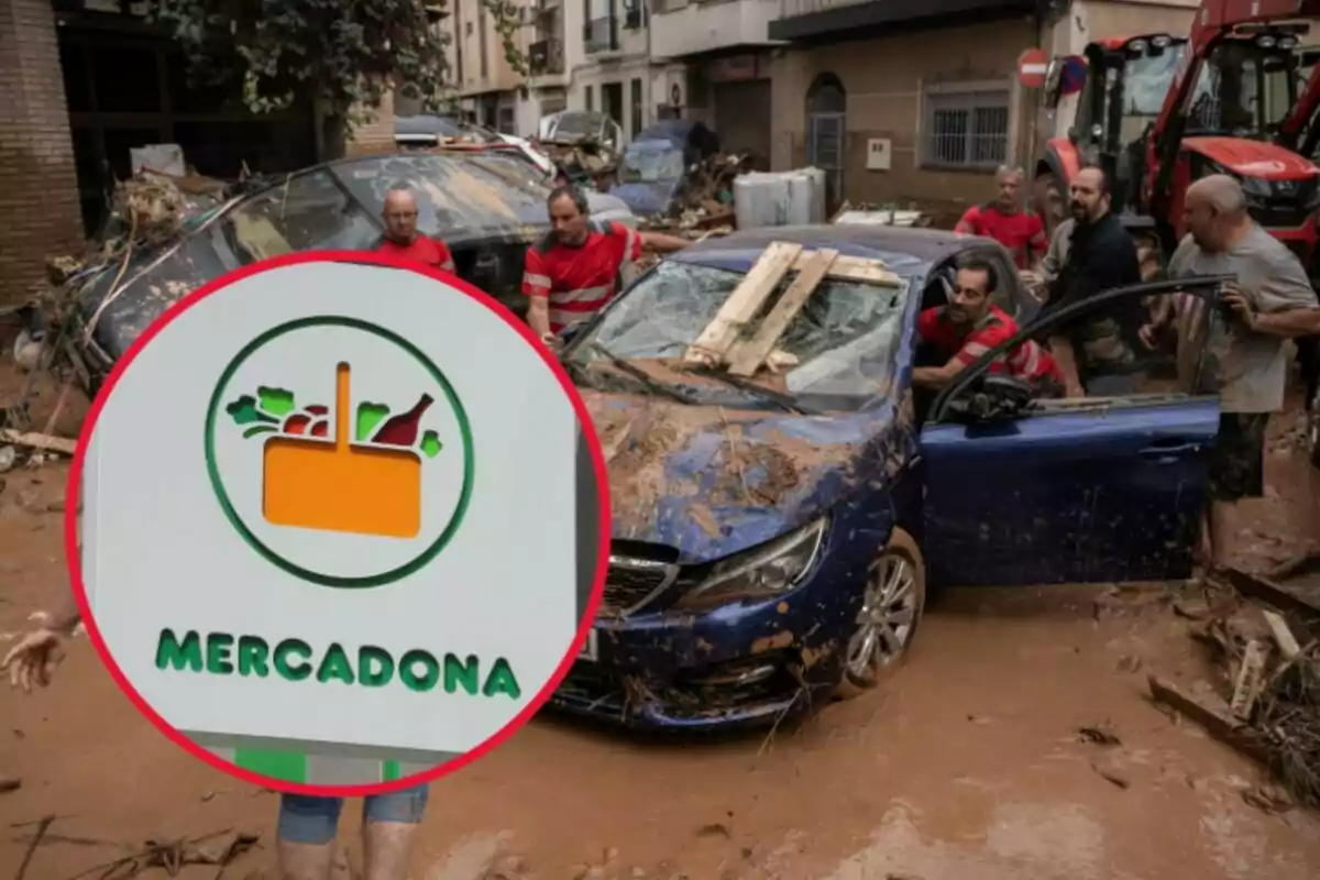 Persones treballant per rescatar un cotxe cobert de fang després d'una inundació en un carrer, amb un cartell de Mercadona en primer pla.