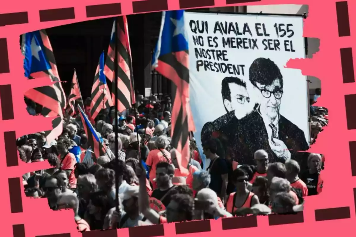 Una multitud de persones amb banderes i un cartell que diu “QUI AVALA EL 155 NO ÉS MEREIX SER EL NOSTRE PRESIDENT” en un marc decoratiu rosa.