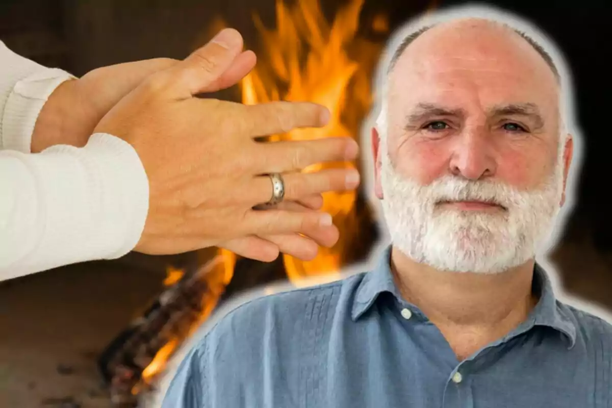 José Andrés amb barba blanca i camisa blava davant d'un fons de foc i mans escalfant-se.