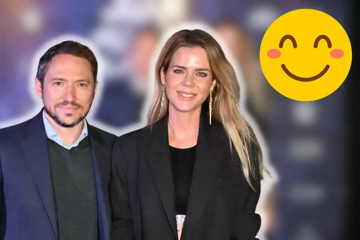 Manuel Martos y Amelia Bono posando juntos en un evento con un fondo desenfocado y un emoji sonriente en la esquina superior derecha.