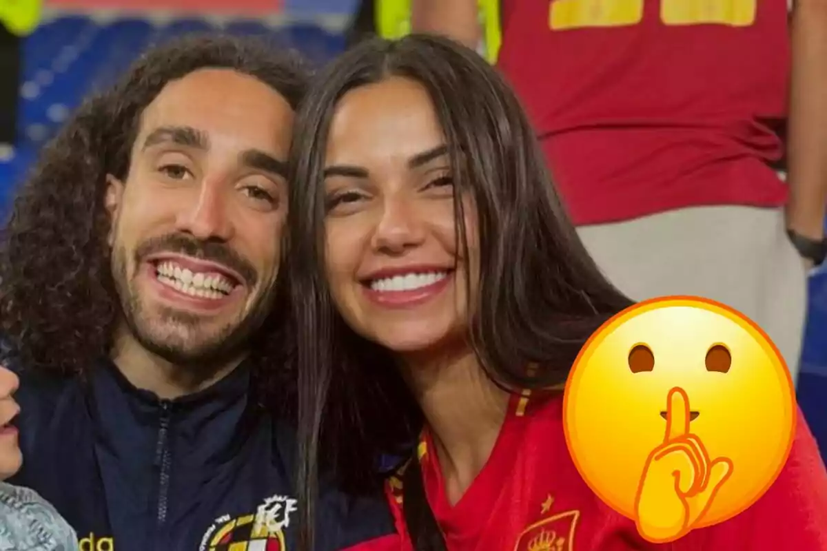 Marc Cucurella i Claudia Rodríguez somrients posen per a una foto, Marc porta una jaqueta amb l'escut de la Federació Espanyola de Futbol i Claudia la samarreta, amb un emoji de "silenci" superposat a la cantonada inferior dreta.