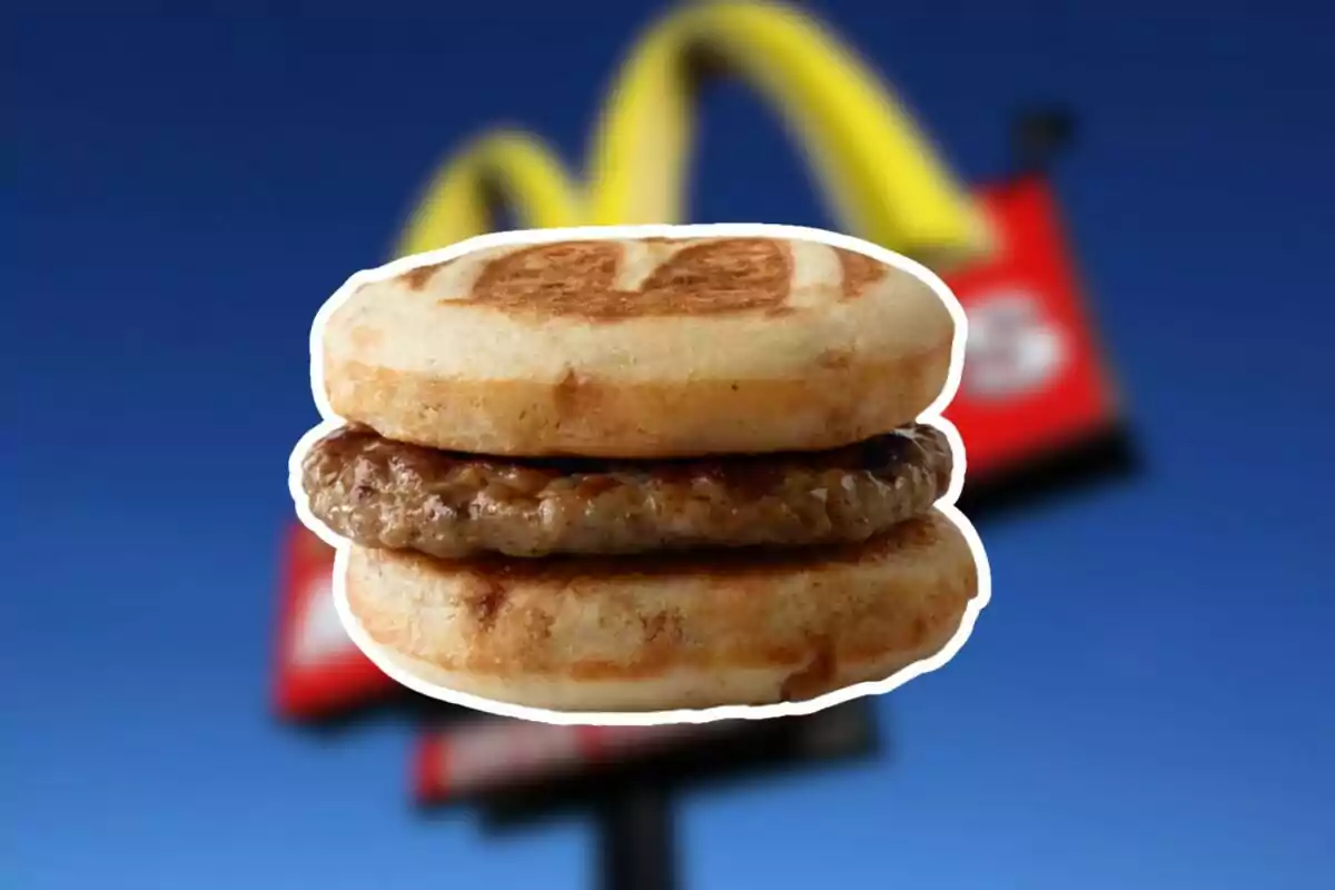 A breakfast muffin with sausage in the center and the McDonald's logo blurred in the background A breakfast muffin with sausage in the center and the McDonald's logo blurred in the background