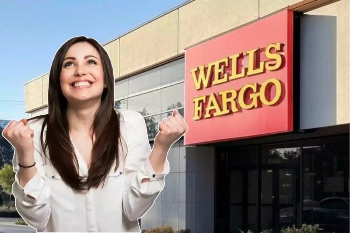 Una mujer sonriente con los puños levantados frente a un edificio de Wells Fargo.