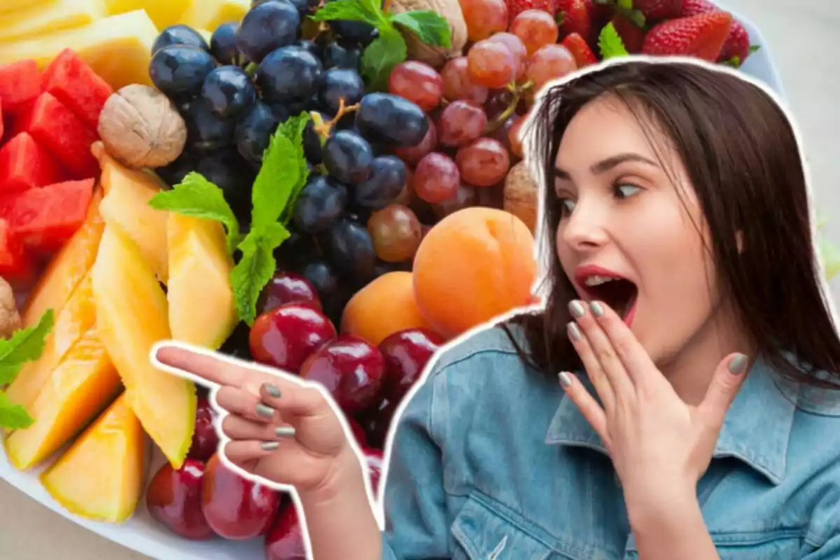 Una dona sorpresa assenyala una safata plena de fruites variades com raïms, maduixes, meló, cireres i nous.