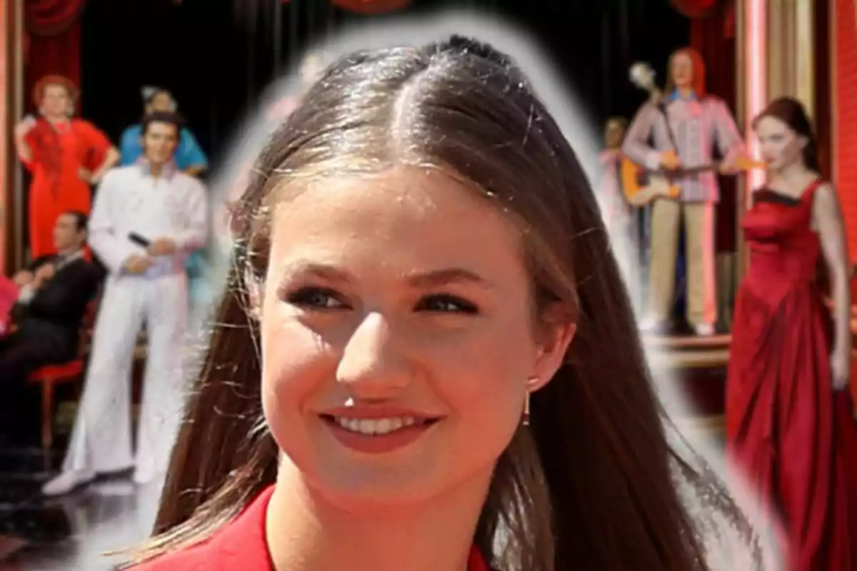 Princess Leonor smiling in the foreground with wax figures in the background.