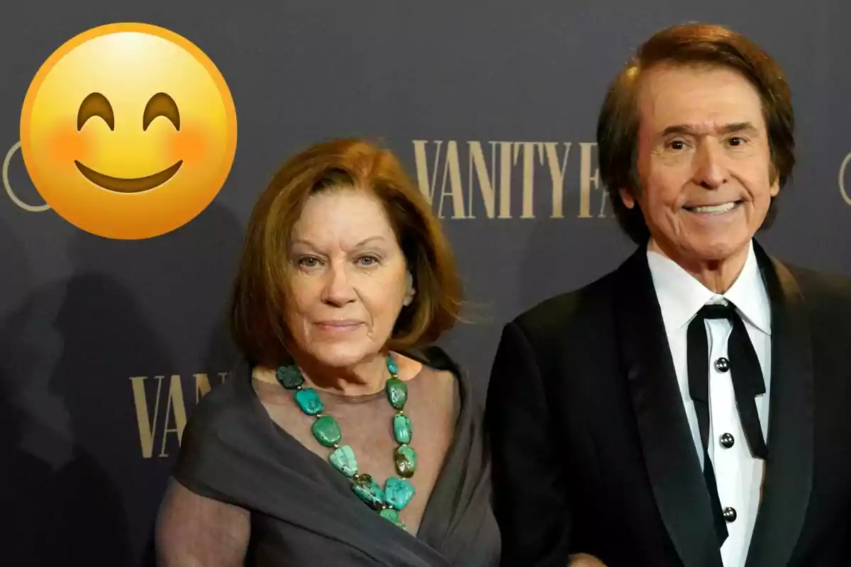 Natalia Figueroa y Raphael posando en un evento de Vanity Fair con un emoji sonriente en la esquina superior izquierda.