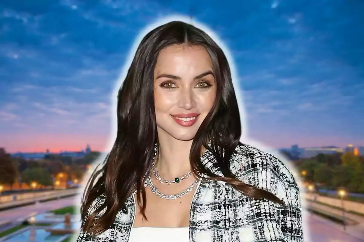 Ana de Armas sonriendo frente a un fondo de cielo al atardecer.