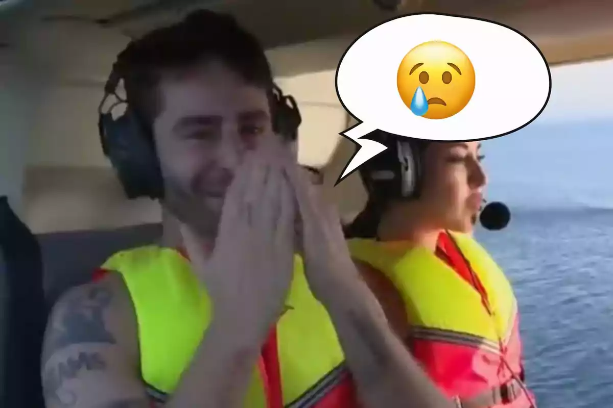 Pelayo Díaz y Samya con chalecos salvavidas y auriculares están en un helicóptero, Pelayo tiene las manos en la cara y un emoji de tristeza en un globo de diálogo.