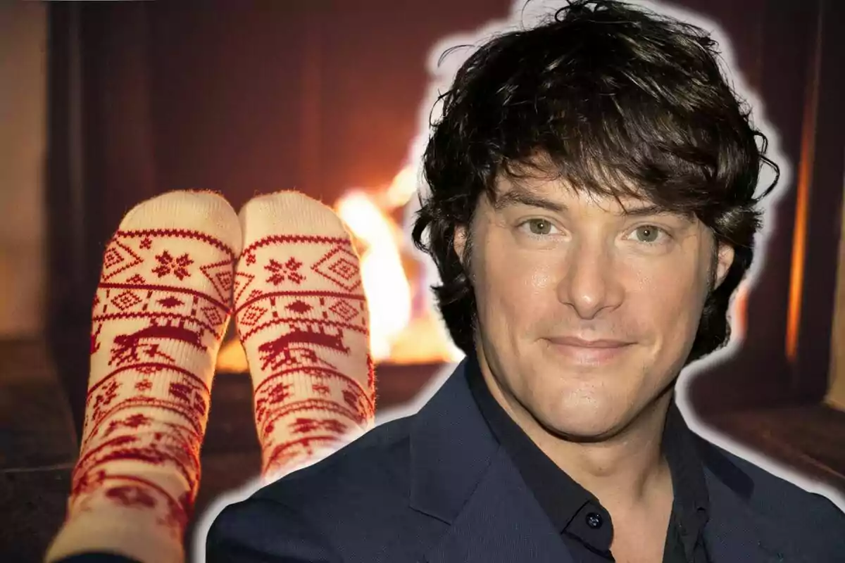 Jordi Cruz con cabello oscuro y una expresión neutral aparece superpuesta sobre una imagen de pies con calcetines navideños frente a una chimenea encendida.