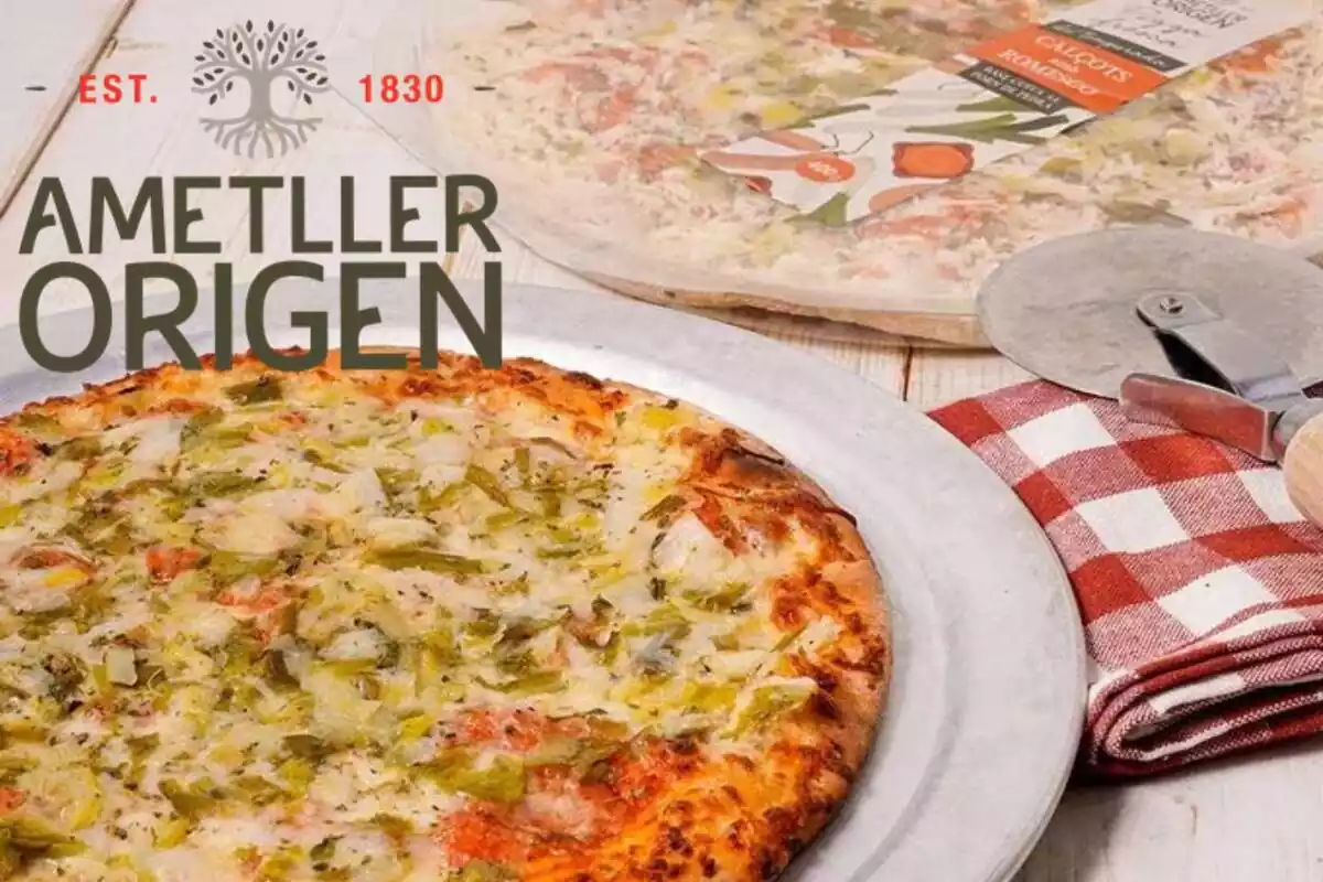 Muntatge amb una pizza de calçot i romesco d'Ametller Origen i el logotip de l'empresa