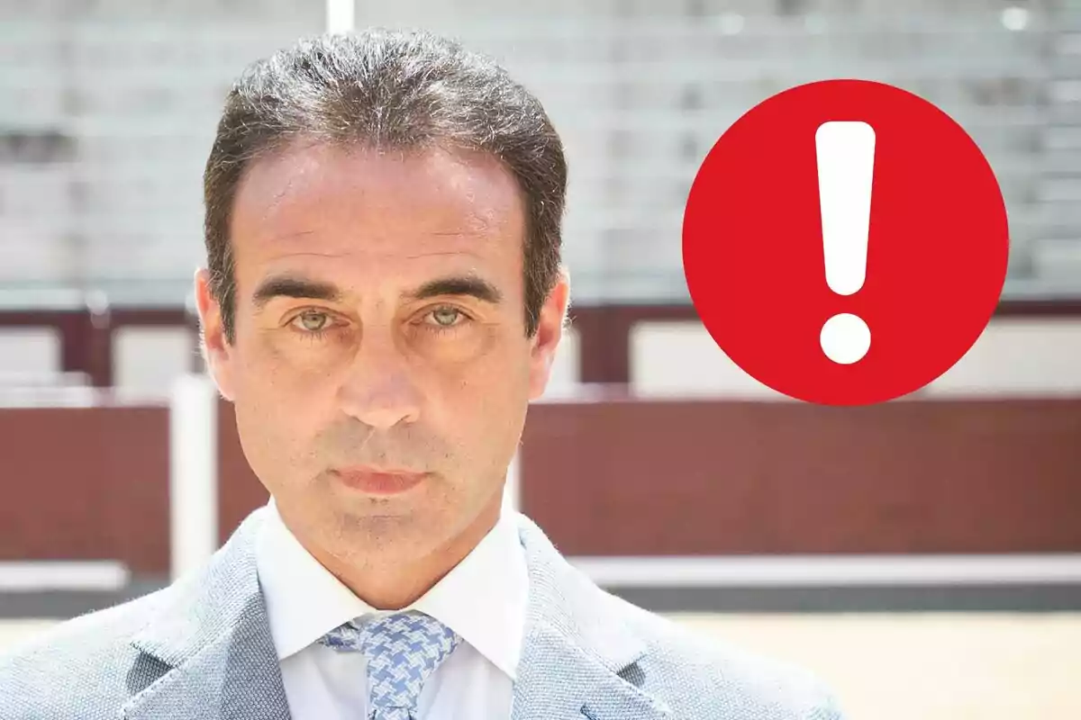 Enric Ponce de vestit amb un símbol d'exclamació vermell al costat.