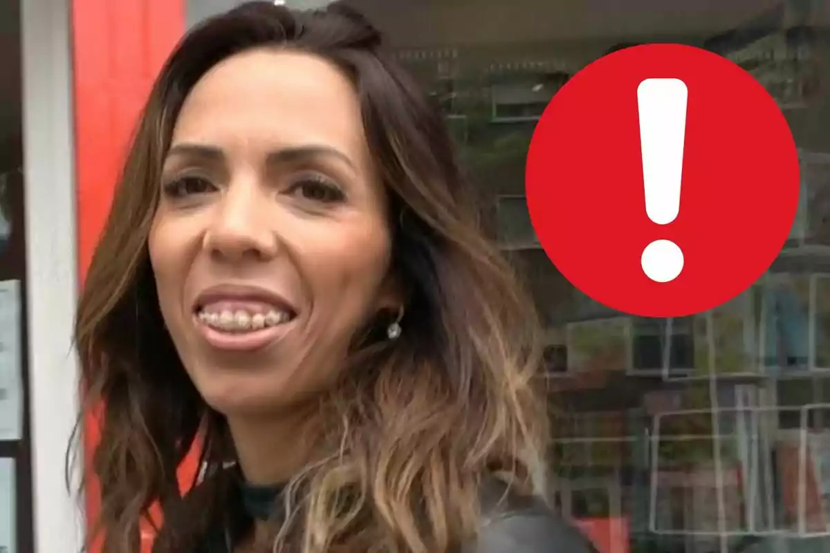 Paola Olmedo sonriendo frente a una tienda con un signo de exclamación rojo en la esquina superior derecha.