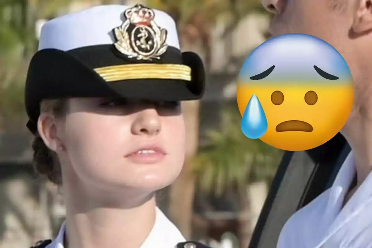 La princesa Leonor amb uniforme militar i gorra està al costat d'una altra persona el rostre de la qual està cobert per un emoji de preocupació.