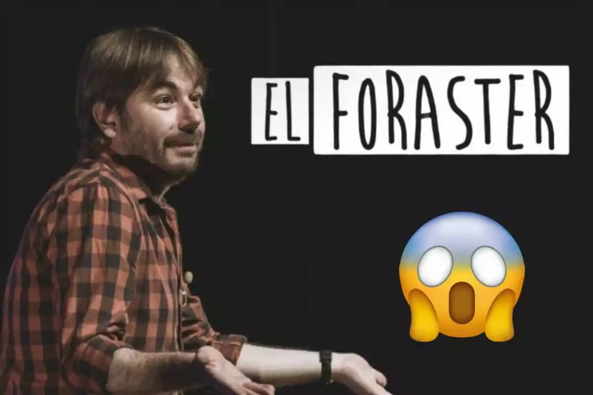 Quim Masferrer amb camisa de quadres vermells i negres davant d'un cartell que diu “El Foraster” i un emoji de cara sorpresa.