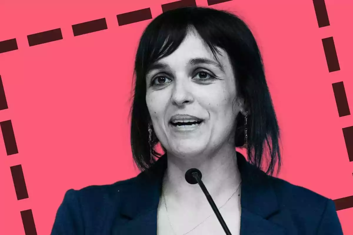 Silvia Orriols parlant davant d'un micròfon amb fons rosa i línies negres.