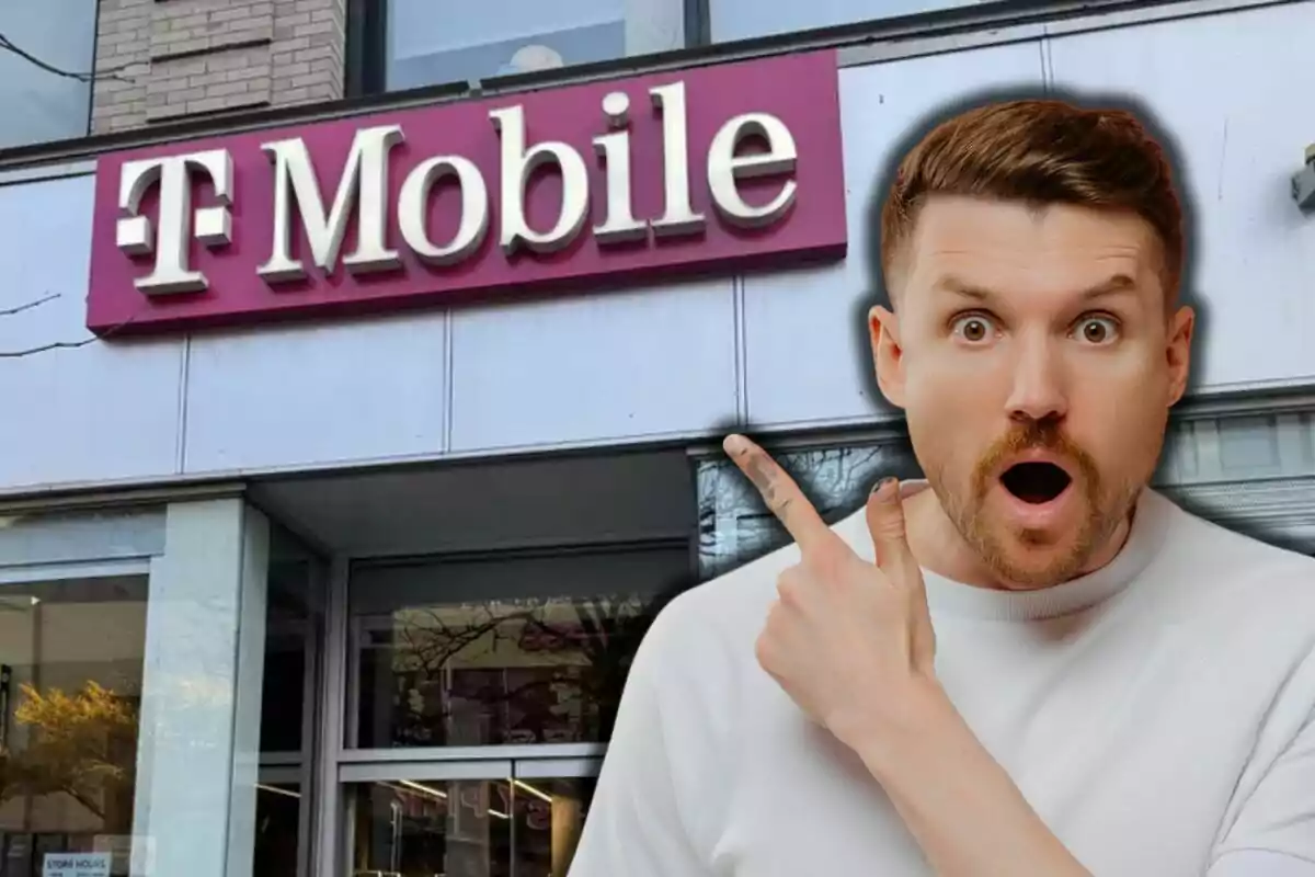 A surprised man points to a T-Mobile sign on the facade of a building.